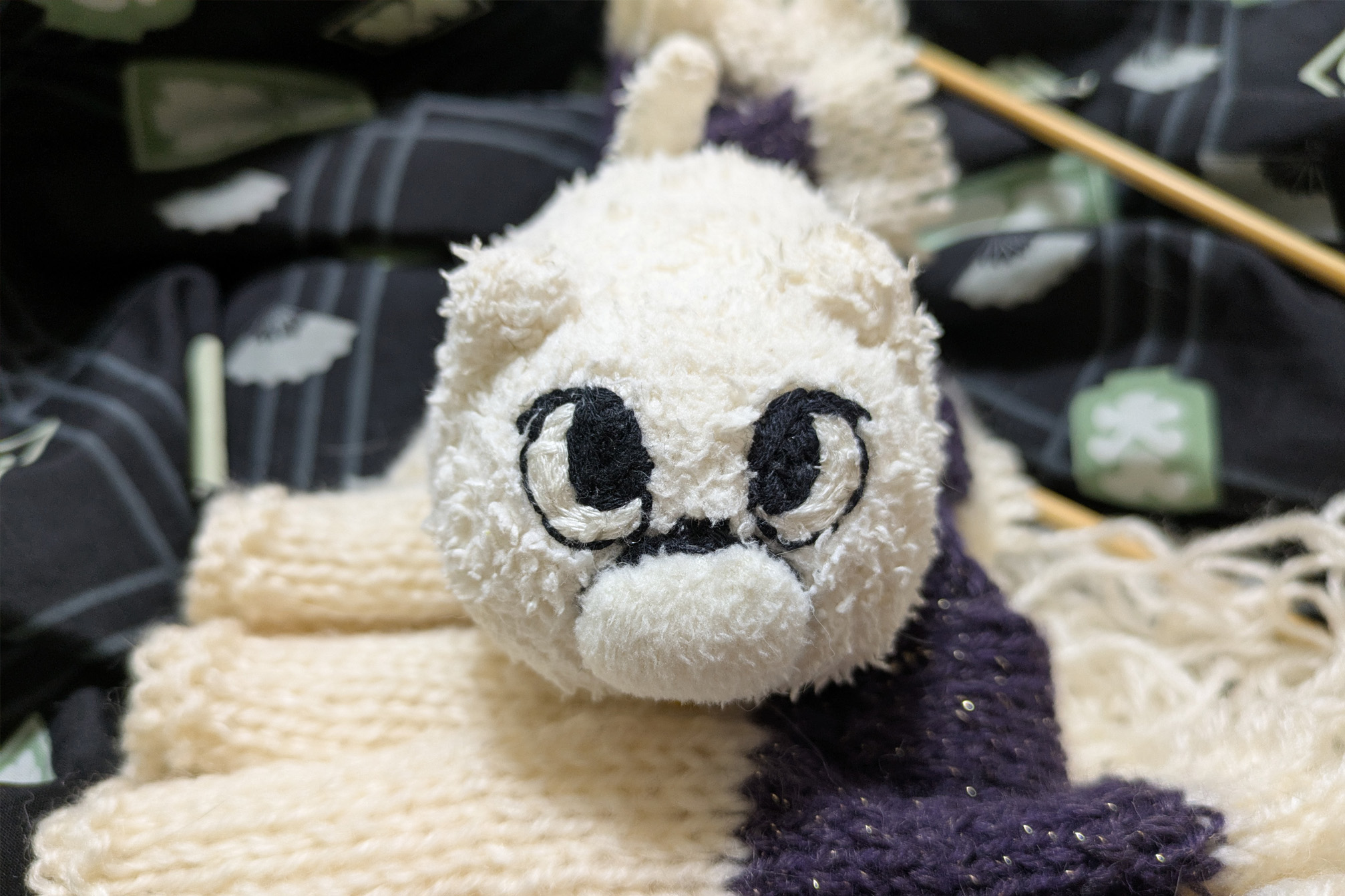 失敗した編み途中のマフラーからこっちを見るマリー